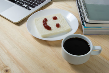 closeup coffee cup and smile on bread, made of strawberry jam