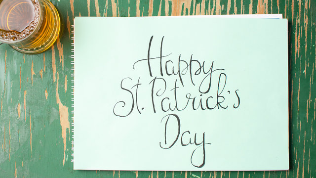 Happy St Patrick day calligraphy card and a beer