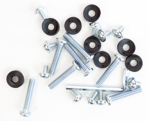 Rubber washes,screws and steel bolts scattered on a white background.