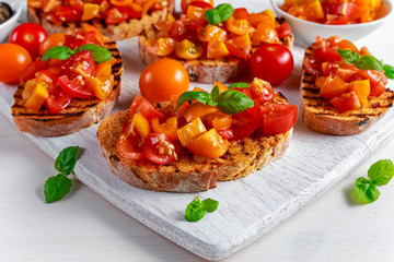 Tasty Traditional Tomato bruschetta with fresh basil on white board