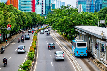 Public transport bus stopped in bus stop, waiting until passenger get in, in busy street at Jakarta, Indonesia. captured in minature, tilt-shit