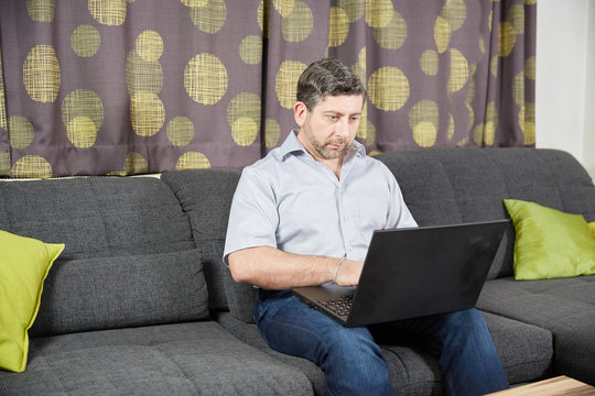 Man with laptop sitting on couch