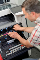 Obraz premium man fixing photocopier