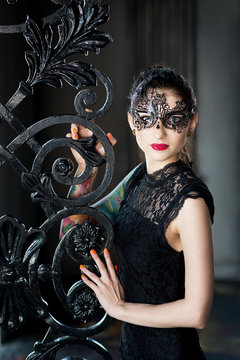 Mysterious Woman In Venetian Carnival Mask Near Wrought Iron Gate