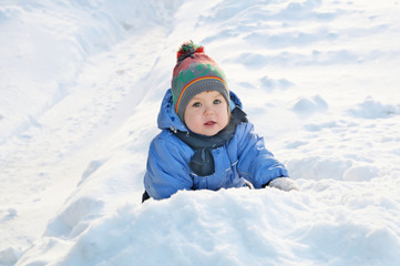 Fototapeta na wymiar Winter activities concept - little girl outside playing in snow