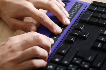 Blind person using computer with braille computer display - 133330727