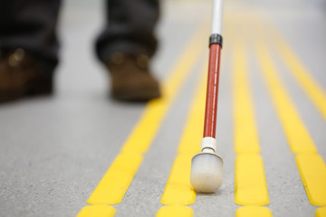 Blind pedestrian walking on tactile paving