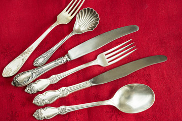 vintage silver cutlery on red tablecloth