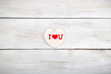 Valentine, a wooden heart on a white wooden background. View fro
