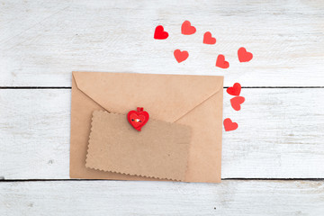 Valentine. envelope kraft paper and red hearts on a wooden backg