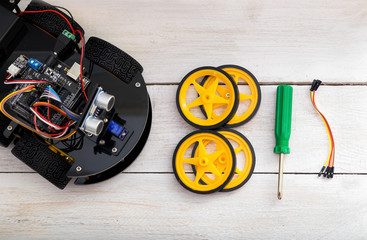 robotics parts. four-wheel drive, a screwdriver lying on a woode