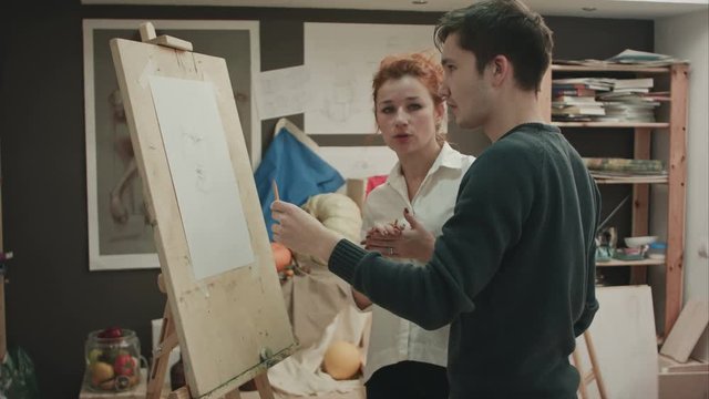 Student and art teacher during painting lesson