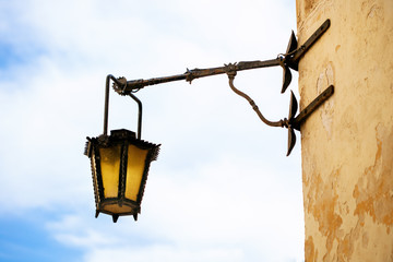 Old black lantern on the stone wall. © Igor Kolos