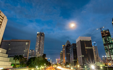 Obraz premium Iconic skyline and heavy traffic in Sudirman Street, Jakarta, Indonesia at dusk, showing light trail of busy traffic and iconic skyscrapers in Jakarta, iluminated by moon light. Urban Skyline, Build