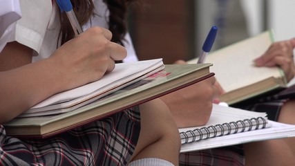 Students Writing In Notepads