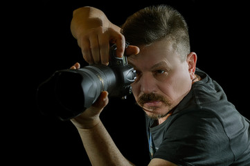 portrait photographer with a camera on  black background