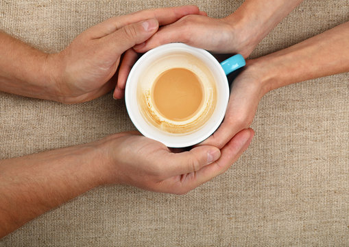 Man and woman hands hold empty latte cappuccino coffee cup