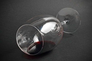 Copa de vino tinto tumbada sobre fondo negro
