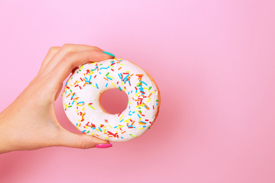 Woman holding delicious donut on color  background