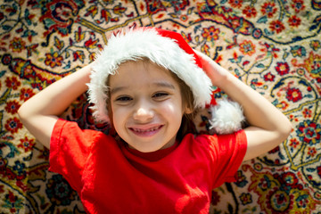 Santa cute kid on carpet at home smiling