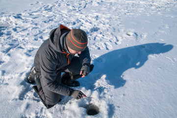 Fototapeta na wymiar Ice fishing. Fisherman in action