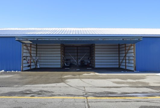 open empty aircraft hangar door lifted up