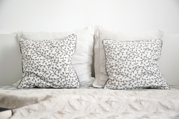 White bedroom detail. Two cushions on a bed. Empty copy space for editor text.