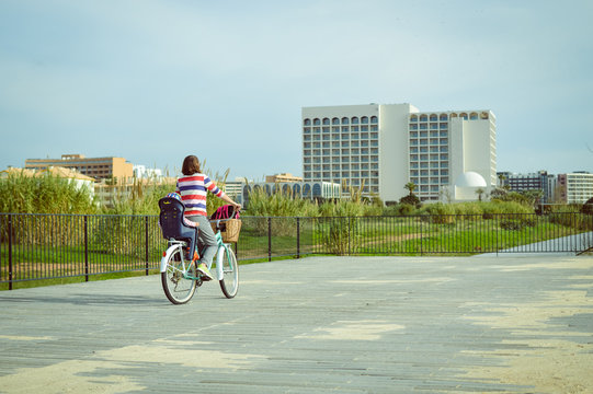 Active mother and child riding a bike together on oudroors background. Back side view blurry image travel journey