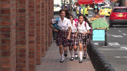 Female Students Running On Sidewalk