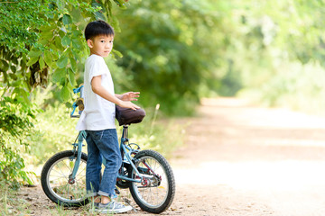 Young boy stand with his bicycle