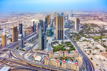 Naklejka na ściany i meble Aerial panoramic view of a big futuristic city Dubai from pinnacle of Bufj Khalifa skyscraper. Business bay, Dubai, United Arab Emirates. Skyline, skyscrapers of down town business center.