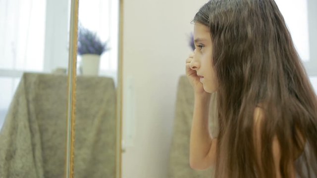 little girl is painted before a mirror her mother's makeup