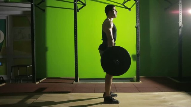 Young man doing deadlift exercise at gym. barbell