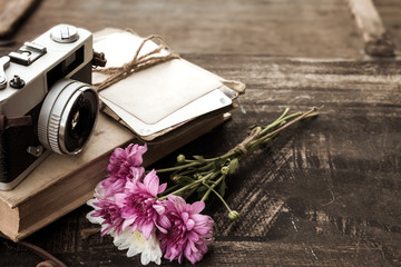 Vintage camera with bouquet of flowers on old wood background - concept of nostalgic and...