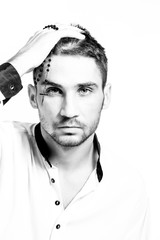 Man with rosary with a cross holding his head. Difficulties faith. Close-up portrait. High key.