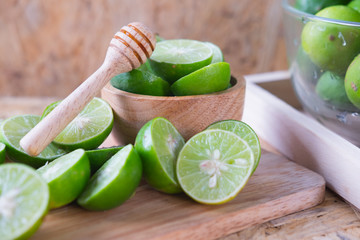 Fresh ripe lime in wooden bowl