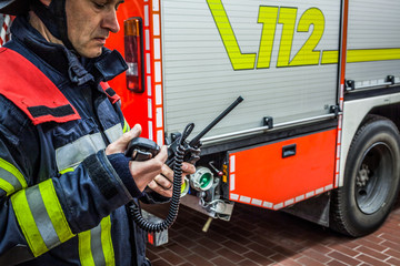 Fototapeta premium Feuerwehrmann im Einsatz mit Funkgerät 