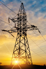 silhouette of power lines in the factory and sunset background.