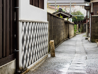 Old style East Asian alley with lattice pattern wall on a rainy day