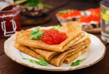 Pancakes with red caviar on plate. Russian cuisine. Maslenitsa