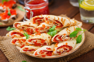 Pancakes with red caviar on plate. Russian cuisine. Maslenitsa