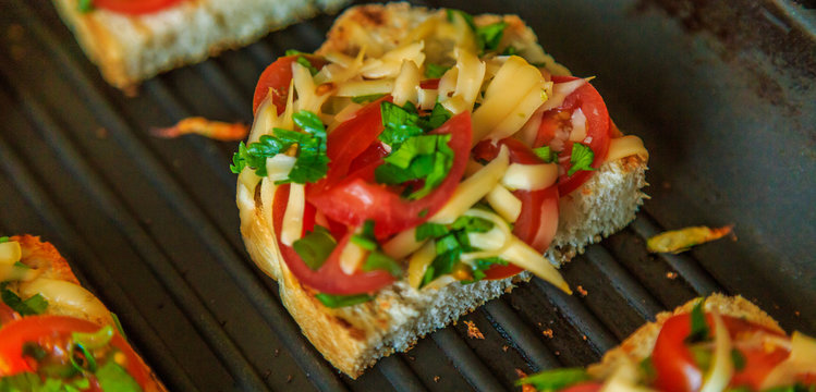 bread grilled with cheese, onions and tomatoes