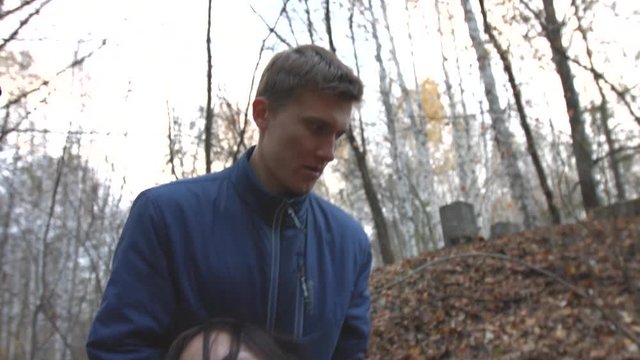 Bandit in the forest threatens weapon.

The man with the gun forces a young man to drag the girl. Slow motion.