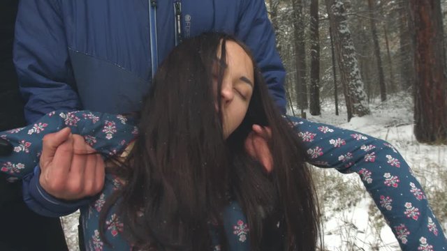 Kidnaping of girl in the winter forest.

Two guys drags in a winter forest beautiful girl in a blue dress. Slow motion.