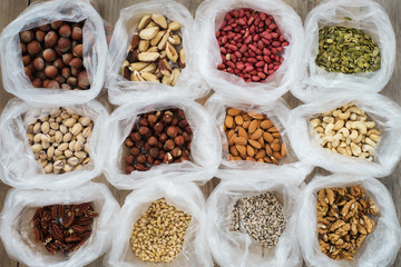 Background of the packages with nuts on a wooden table, top view