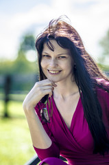 
Girl with vesnuschkami and dark hair in the park with sunglasses
