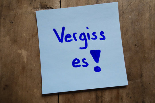 Post it memo on wooden table, Vergiss es