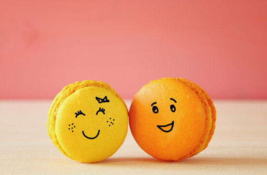 Image of two cute macaroons with drawn smiley faces