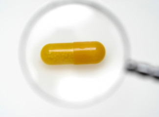 Pill and a magnifier glass