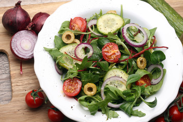 Caprese. Caprese salad. Italian salad. Mediterranean salad. Italian cuisine. Mediterranean cuisine. Tomato mozzarella basil leaves black olives and olive oil on wooden table. Recipe - Ingredients